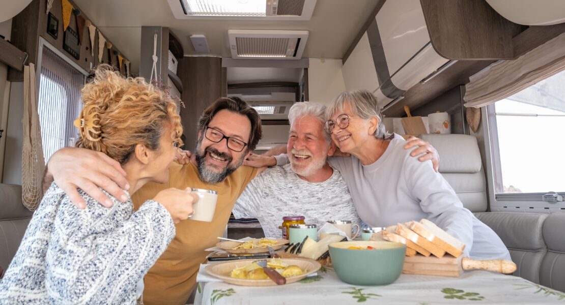 Family of four sat around dining table in a motorhome